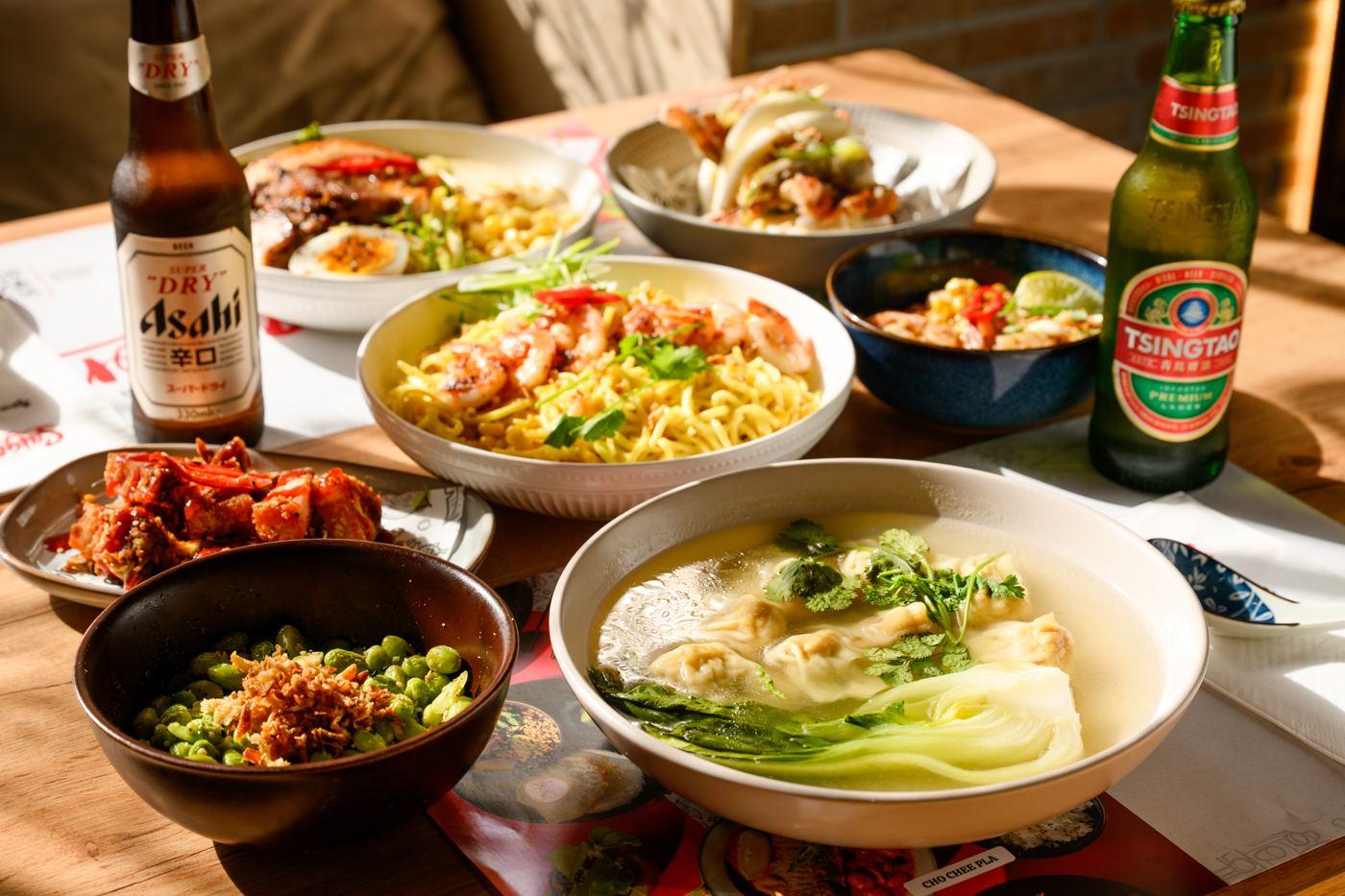 A full table of Asian dishes and cold beers at Saigon Malta