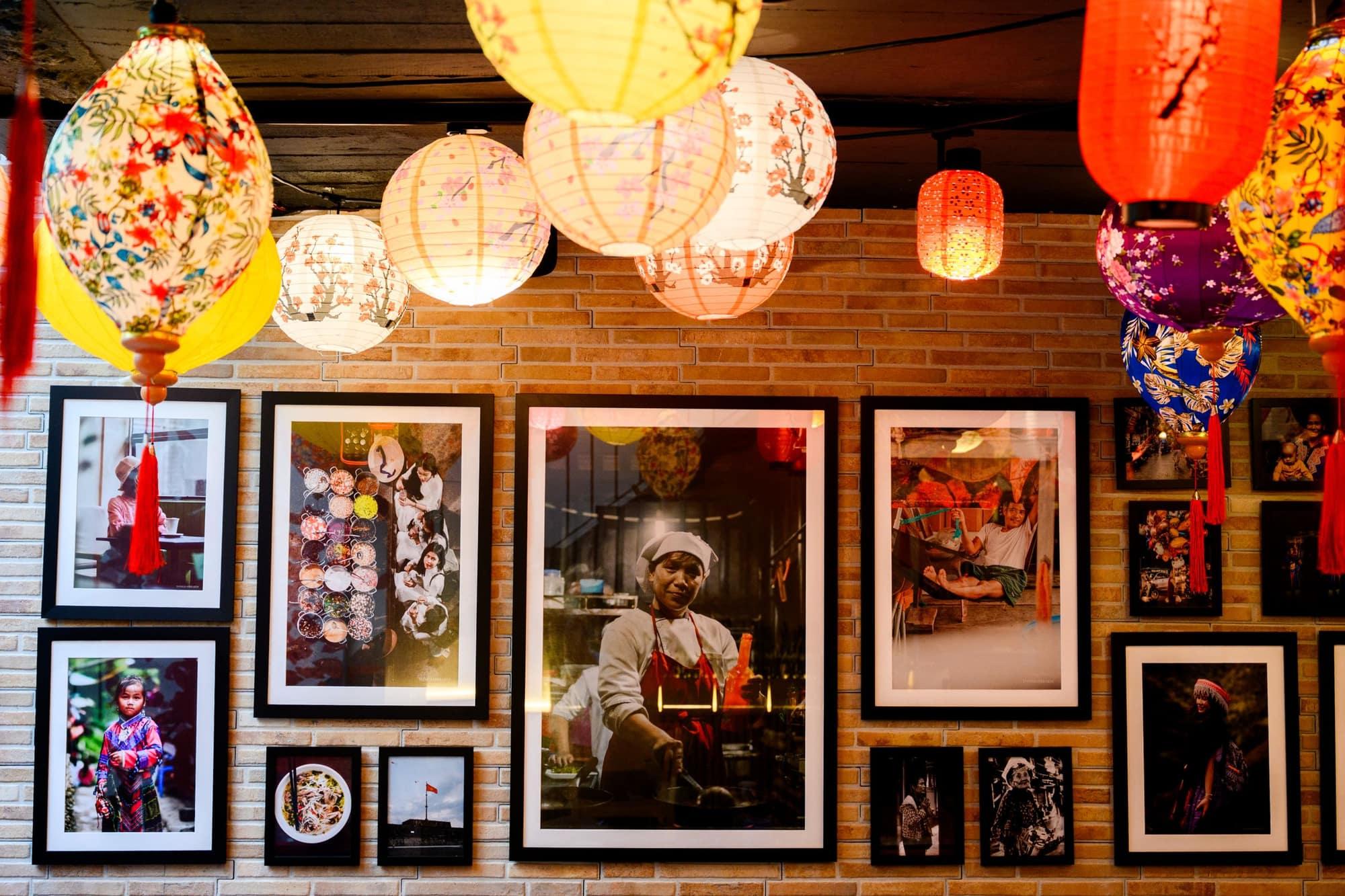Lantern-lit wall of framed photography at Saigon